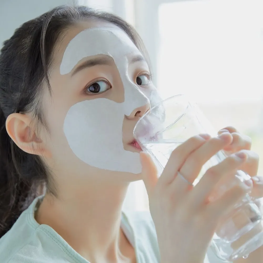 Cô gái tạo dáng với lớp mặt nạ đất sét trên gương mặt.