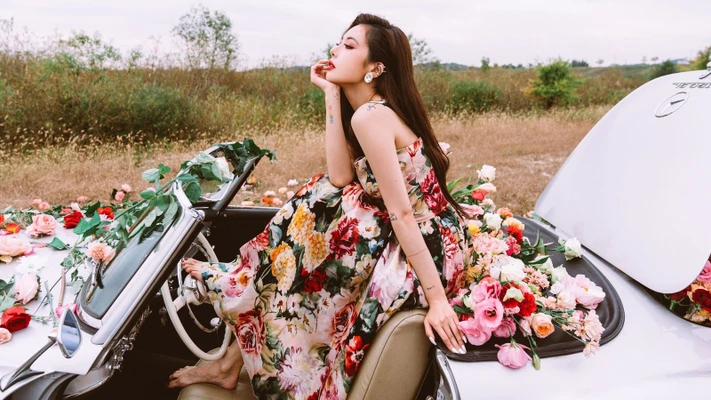 HyunA mặc đầm hoa ngồi trên ô tô trong MV nhạc KPOP Flower Shower