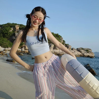 Cô gái xỏ khuyên rốn chụp hình bên bờ biển