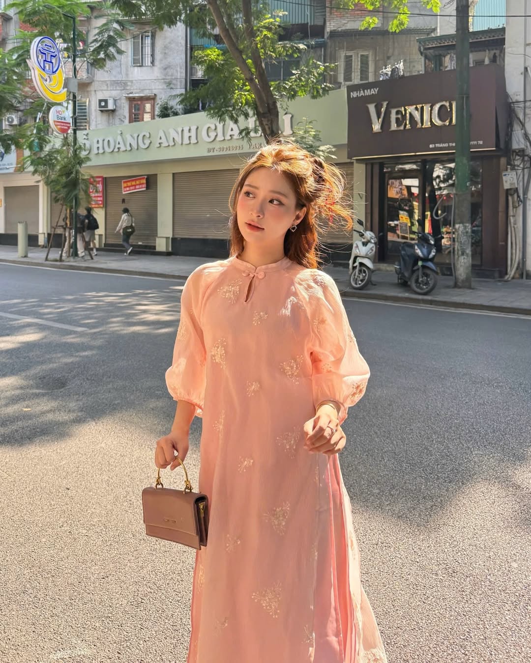 Những nhành hoa thêu nổi làm bừng sáng phom dáng truyền thống của tà áo dài.