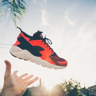 chụp ảnh giày sneakers đỏ đen trước ánh mặt trời