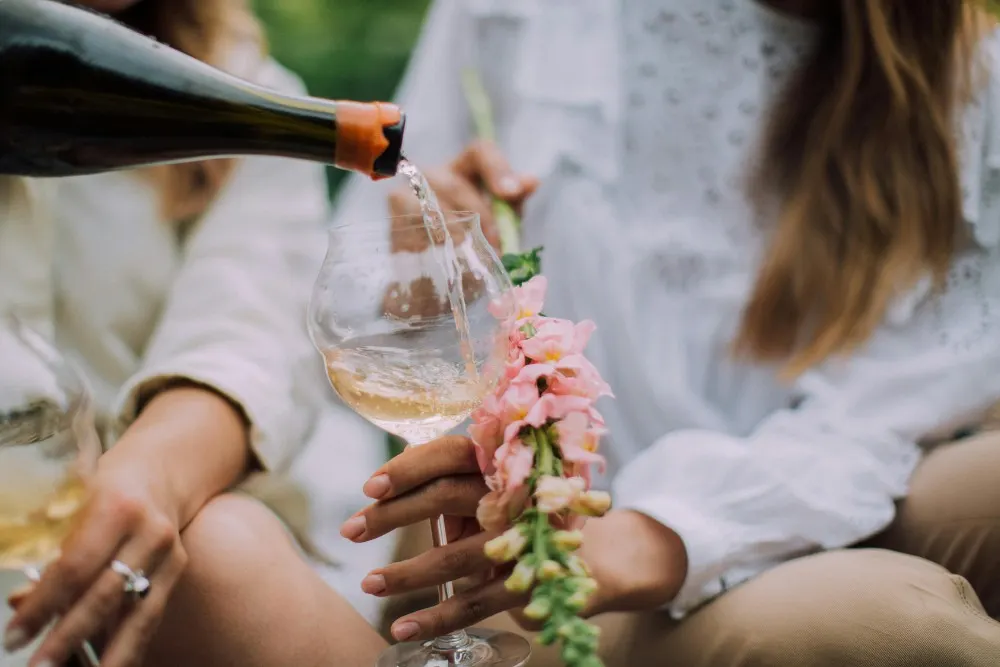 Cô gái đang rót rượu champagne