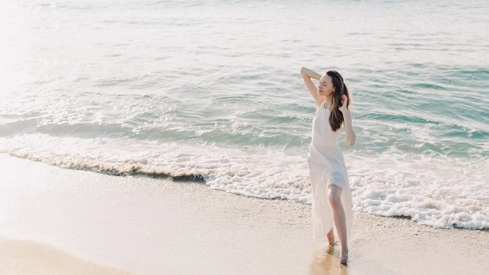 người phụ nữ đứng bên bờ biển