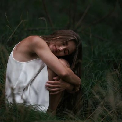 cô gái mặc váy trắng ngồi trên bãi cỏ cúi người mơ màng tử vi ngày 26/2/2026