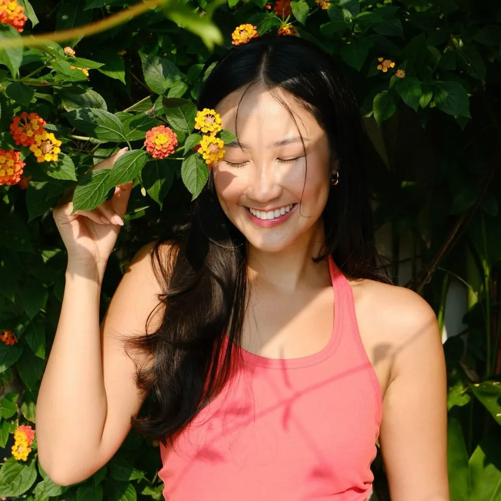 Hình ảnh Sabrina Uyên Lưu cười dưới tán cây và nắng.