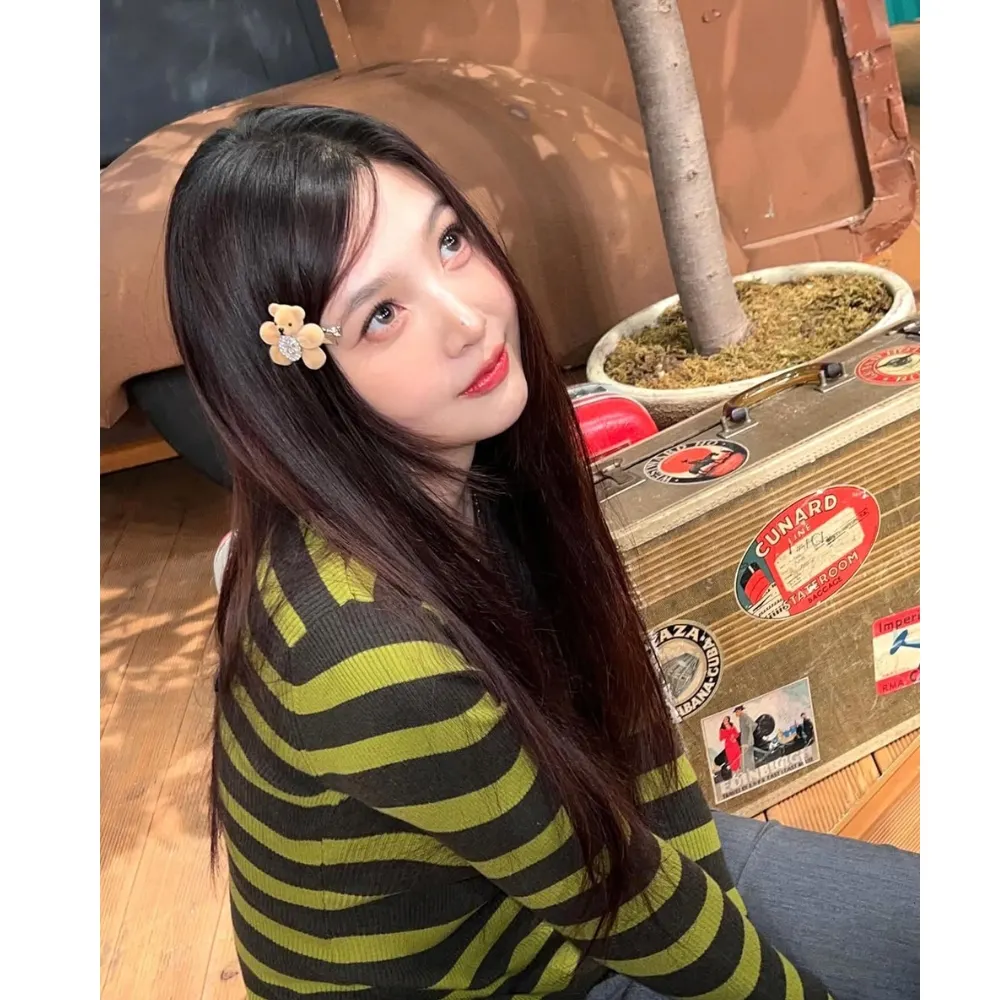 Joy (Red Velvet) cài gấu nhồi bông lên mái tóc.