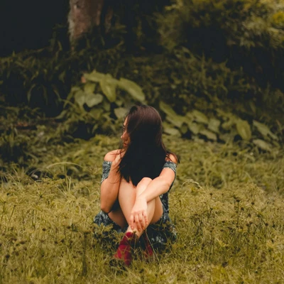 cô gái ngồi trên thảm cỏ trước khu rừng tử vi ngày 28/4/2026