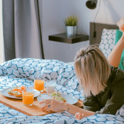 Cô gái nằm trên giường ăn sáng - chế độ ăn