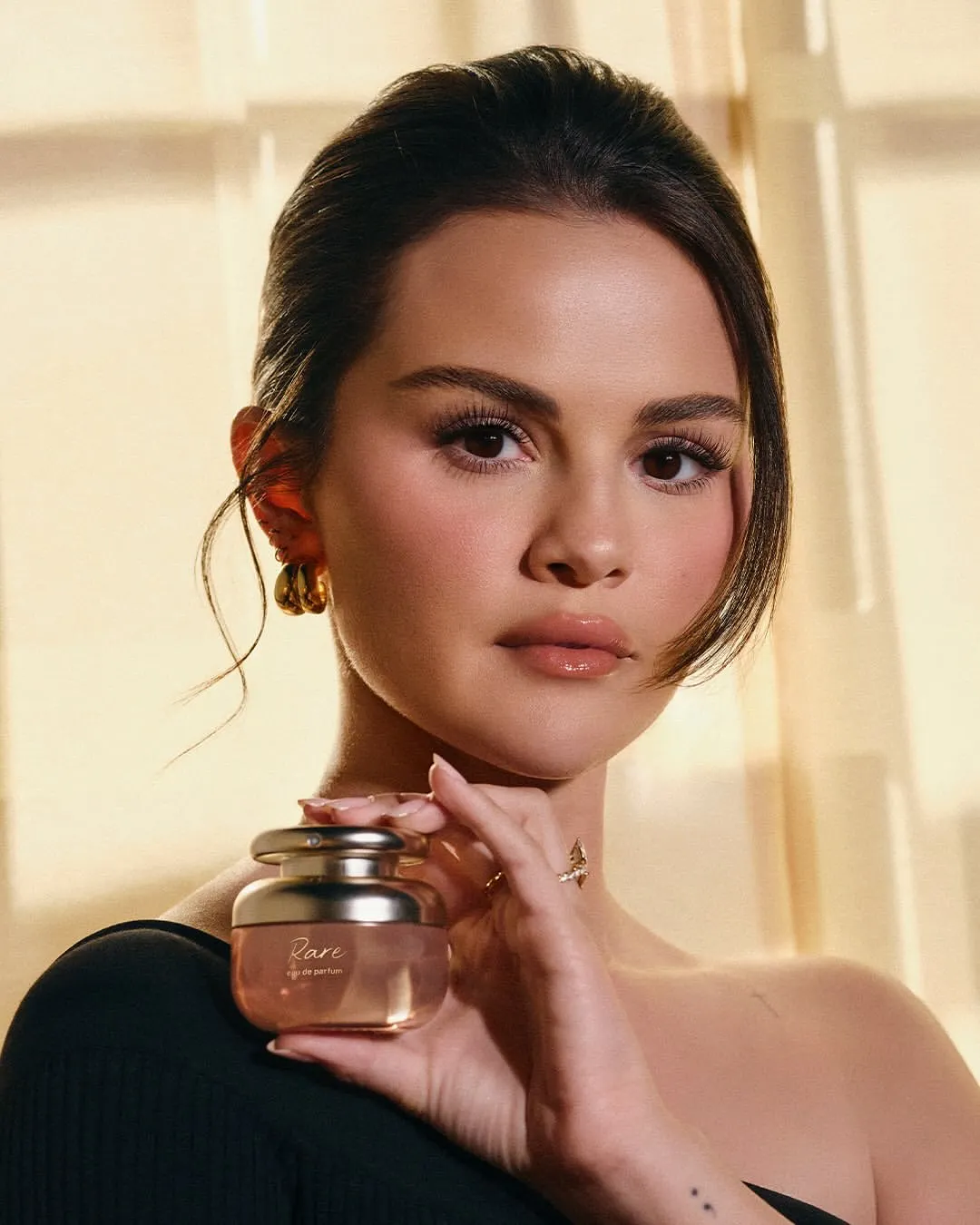 Selena Gomez cầm chai Rare Eau de Parfum – nước hoa đầu tiên của Rare Beauty.