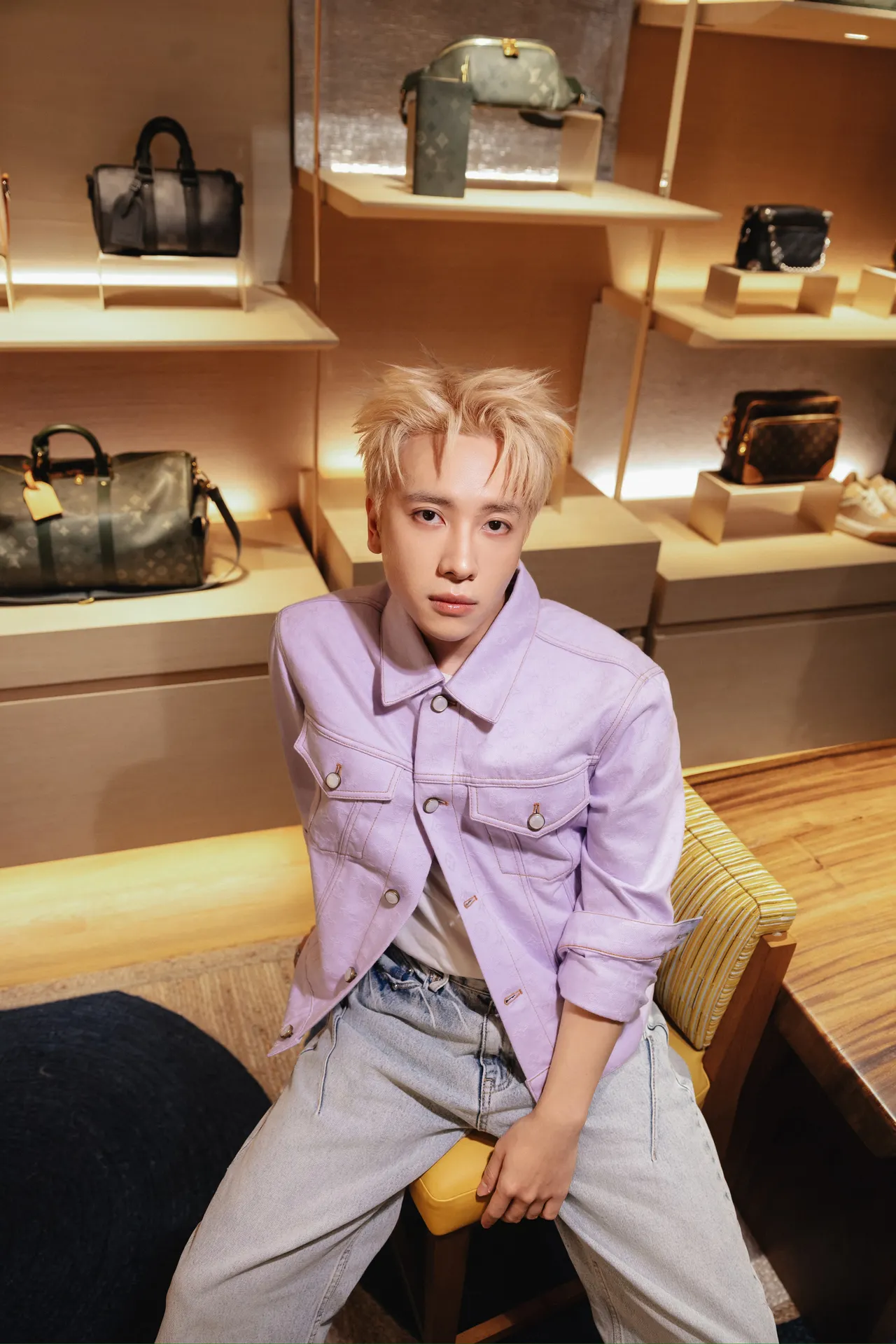 Nicky chọn phong cách trẻ trung với áo khoác denim màu tím nhạt và quần jeans xanh cơ bản kết hợp cùng giày thể thao nâu dập logo LV.