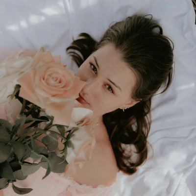 cô gái cung hoàng đạo ôm hoa nằm trên cỏ