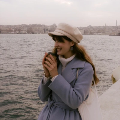 cô gái đội mũ đang cầm cốc cà phê