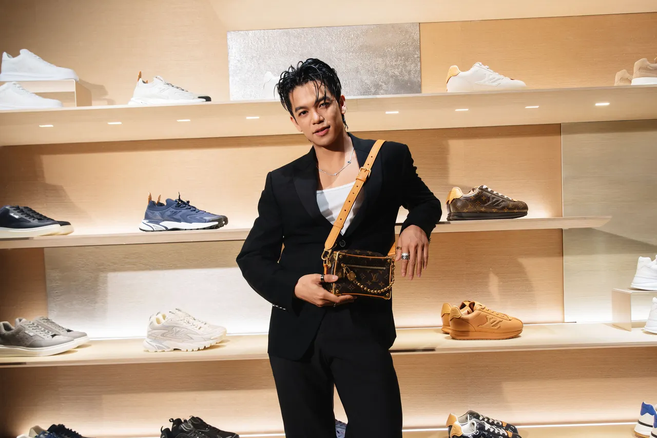 Trọng Hiếu xuất hiện trong bộ suit đen, nhấn nhá bằng thắt lưng logo LV và túi xách dạng hộp cứng cổ điển.