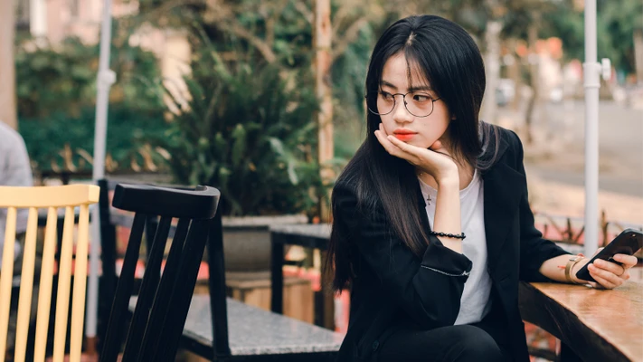 cô gái ngồi bên bàn