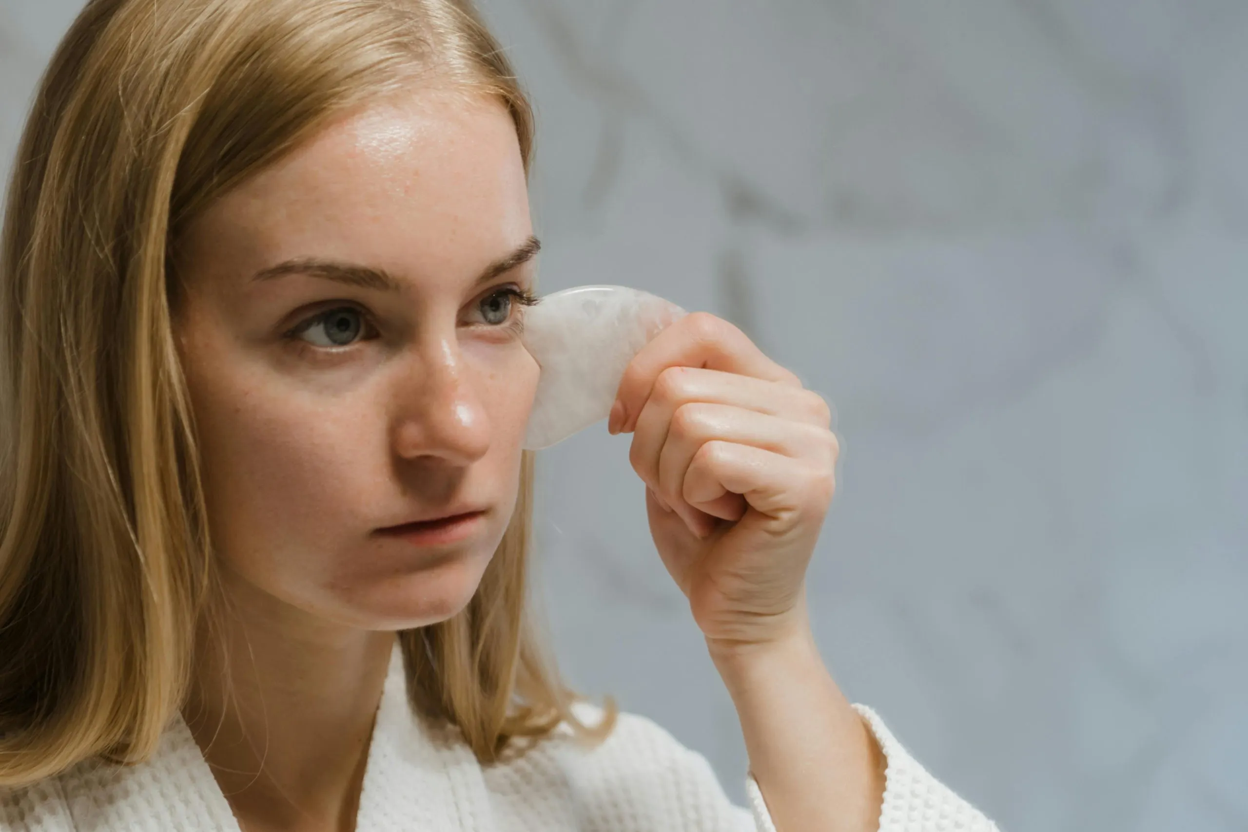 cô gái massage mặt với đá gua sha