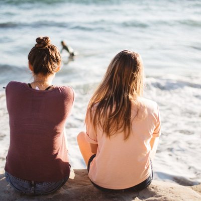 hai cô gái ngồi trên bãi biển