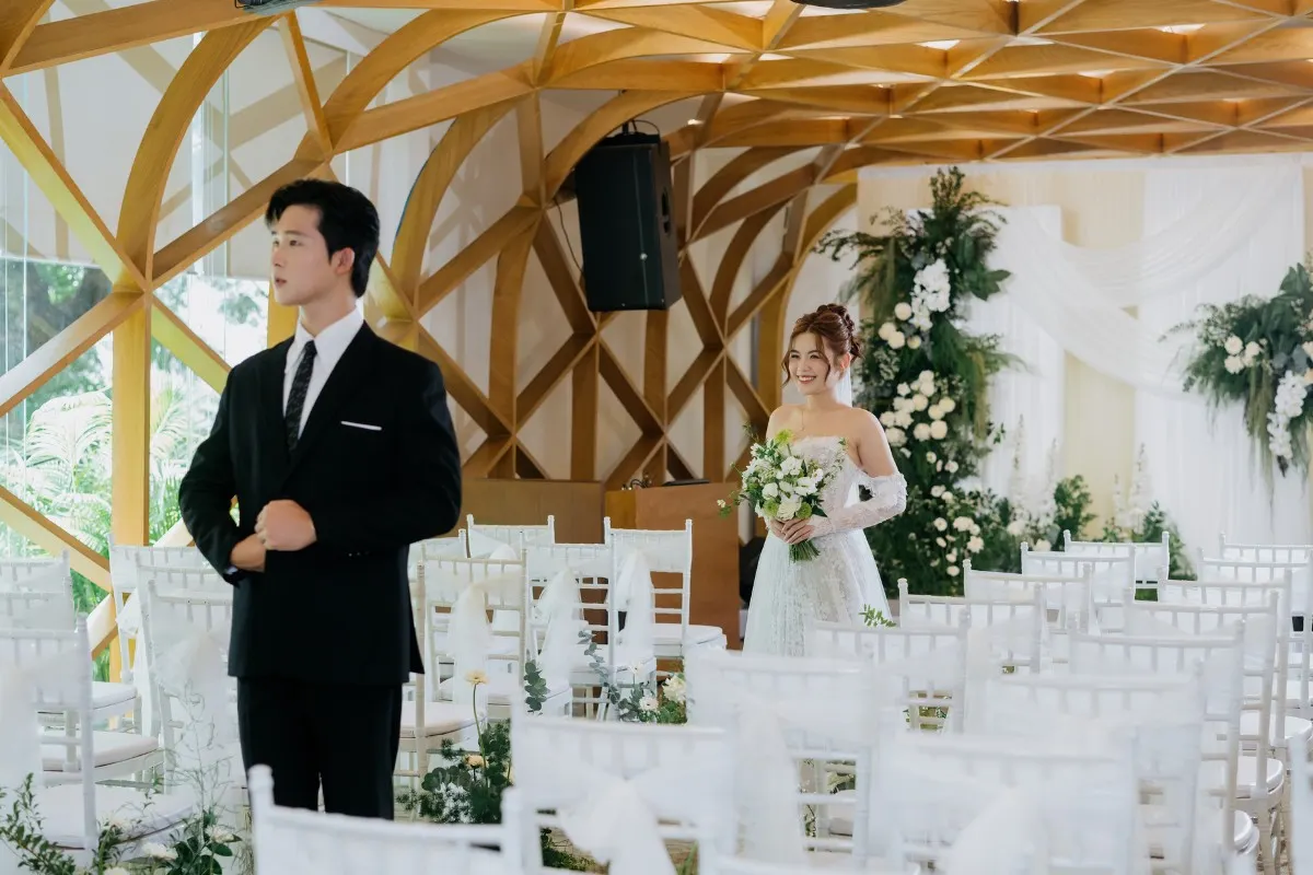Chú rễ đứng quay lưng chỉnh trang vest đợi cô dâu tươi cười bước vào lễ đường