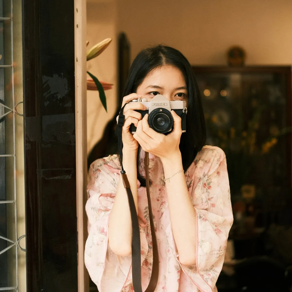 Cô gái tóc đen đứng bên cửa cầm máy chụp hình tìm thấy niềm vui theo cung hoàng đạo