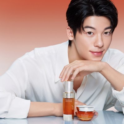 nhân sâm - diễn viên Hứa Quang Hán mặc áo sơ mi màu trắng và tạo dáng chống cằm để chụp cùng bộ sản phẩm dưỡng da của Sulwhasoo