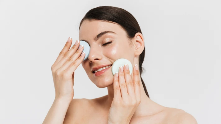cô gái cười nhẹ đặt hai tay lên mặt