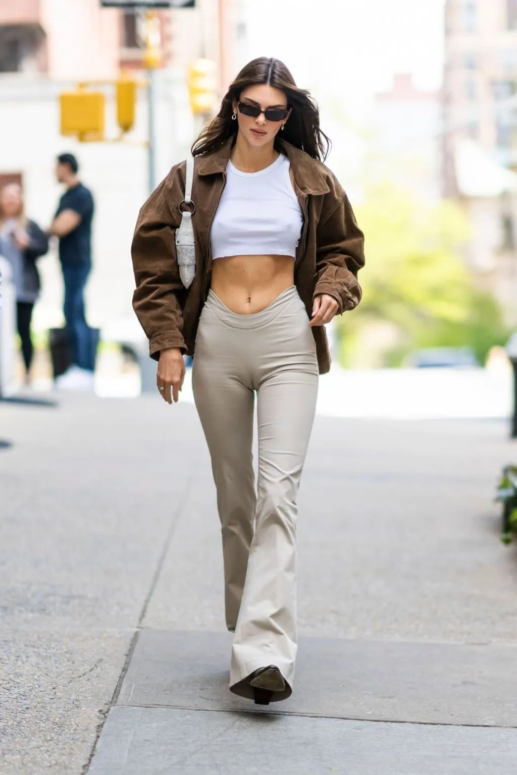 Quần legging ống loe beige kết hợp giày sneakers chunky và crop top trắng.