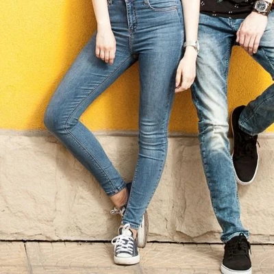 quần jeans nam và nữ đứng trước bức tường vàng