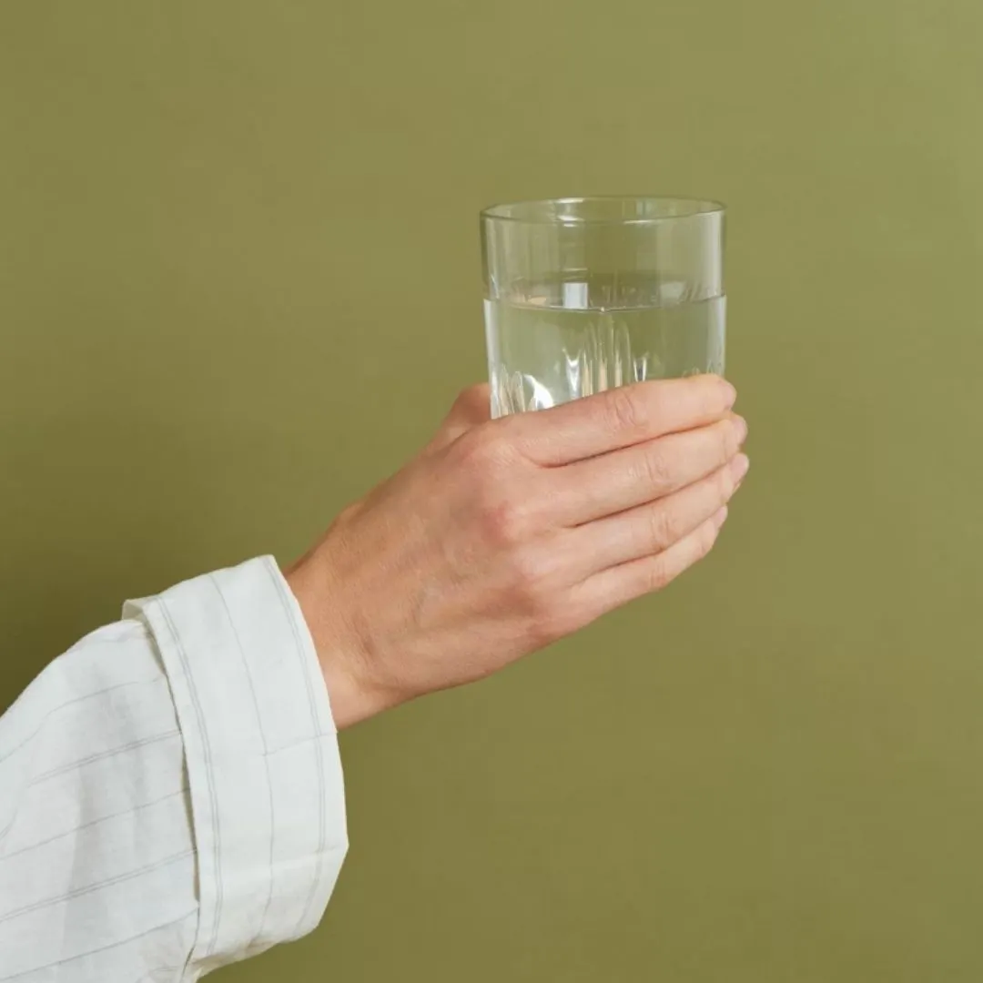 tay cô gái cầm ly nước lọc