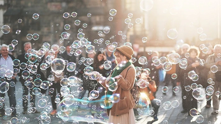 cô gái đứng giữa bong bóng xà phòng