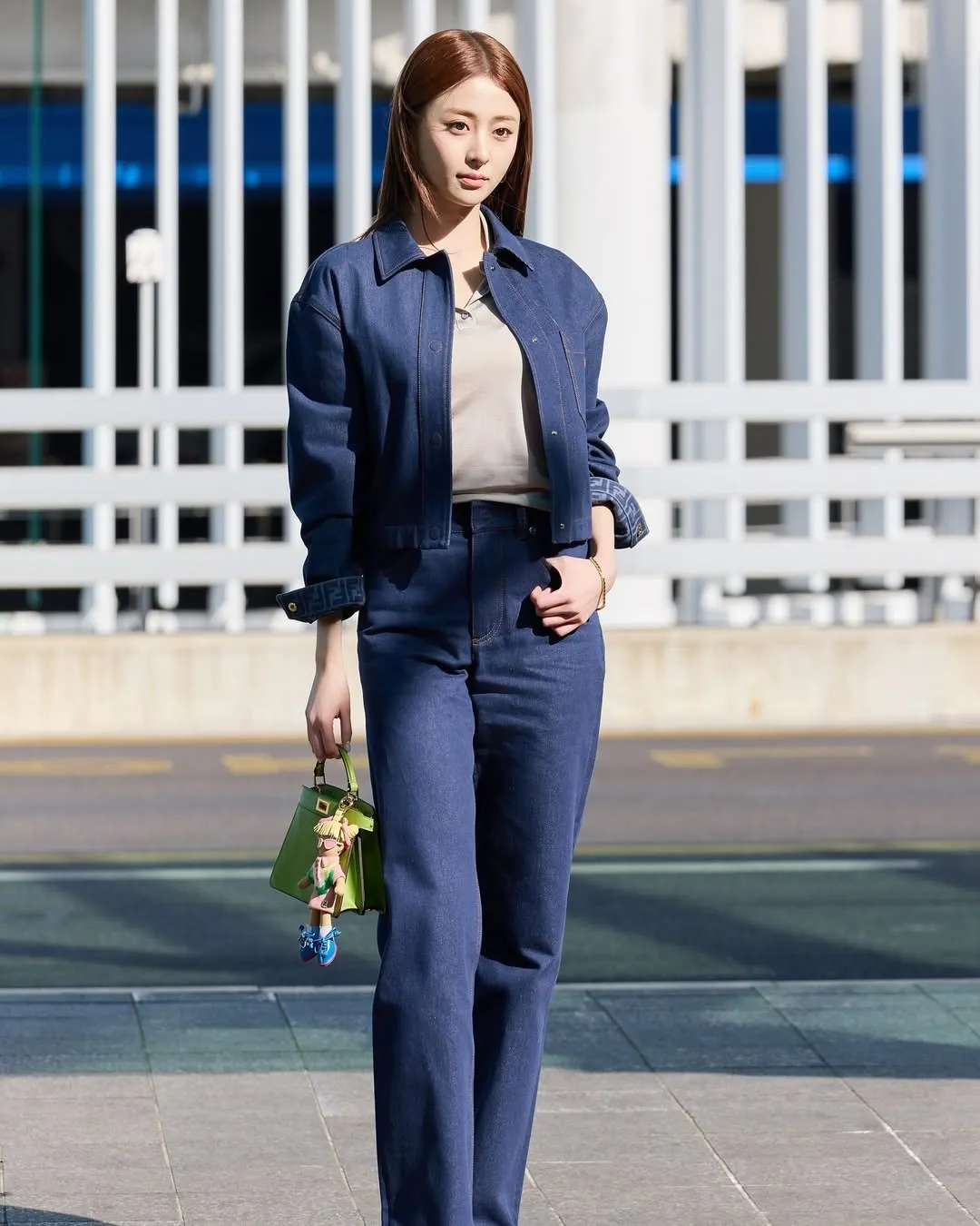 Huh Yun-jin tạo điểm nhấn layering ngẫu hứng với túi Fendi xanh thẫm, biến thời trang sân bay thành bản hòa ca của sức sống trẻ.