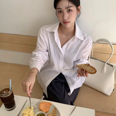 phụ nữ trẻ trong trang phục tối giản đang dùng bữa sáng với bánh mì, thịt nguội và trứng giàu collagen