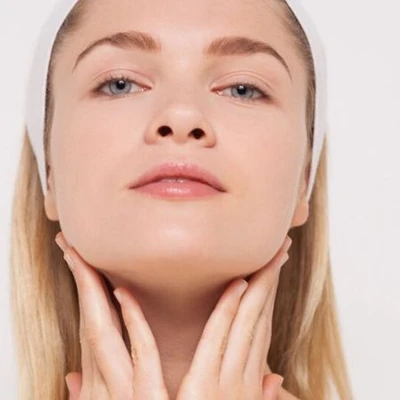Massage cổ-Cô gái áp tay lên cổ.