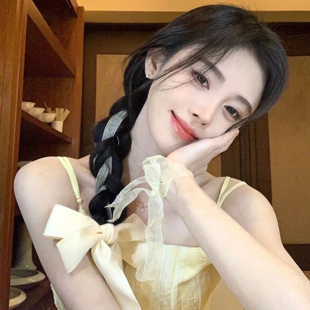 Cô gái tết tóc đuôi sam chống tay lên má