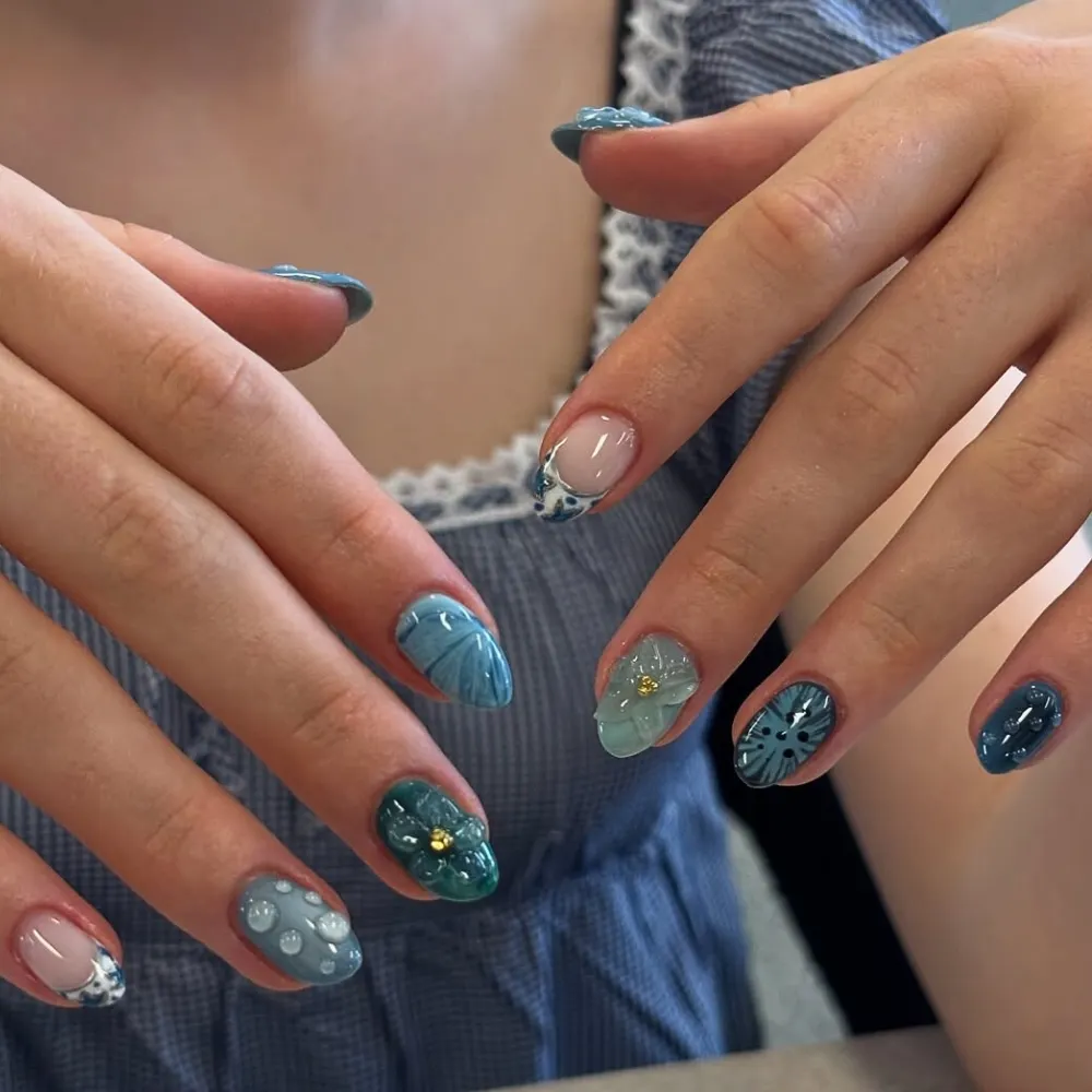 Đôi bàn tay với kiểu nail lấy màu xanh dương đậm làm chủ đạo