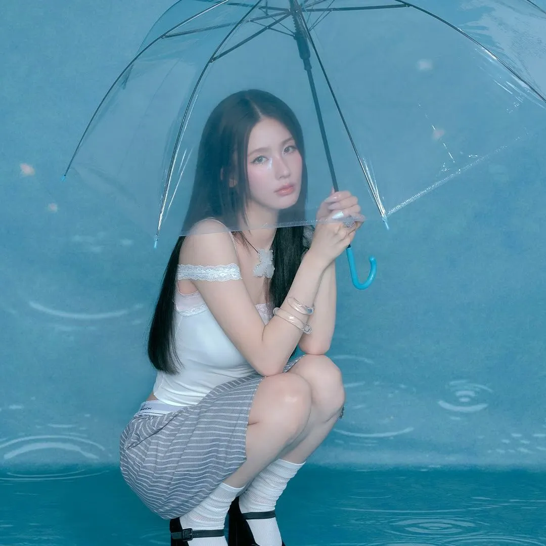 Cô gái cầm ô trong không gian xanh nhạt - chăm sóc sức khỏe mùa mưa