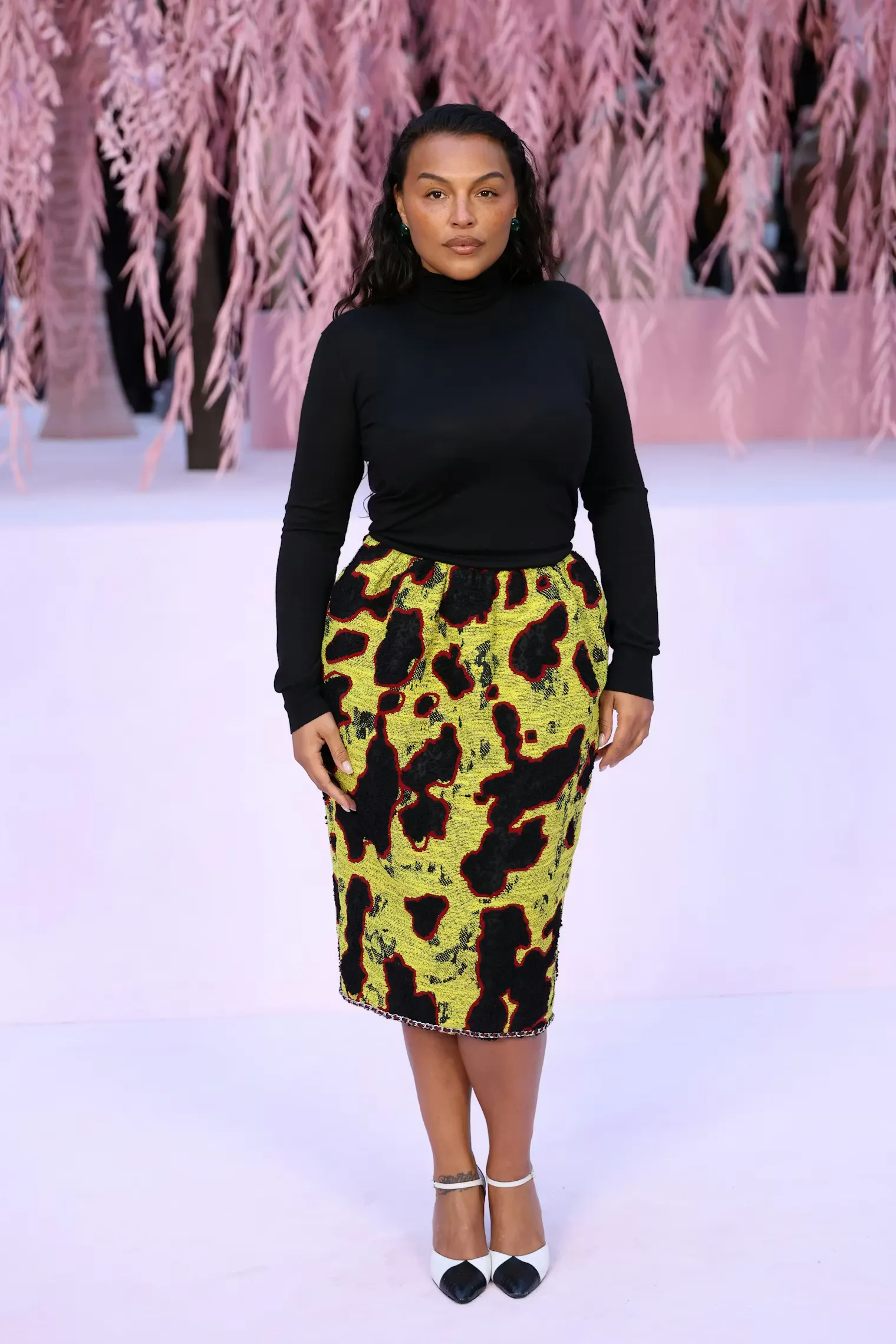 Paloma Elsesser: Nàng mẫu đình đám khoe vẻ gợi cảm trong chiếc áo cổ lọ đen đơn giản phối cùng chân váy bút chì vải tweed họa tiết vàng-đen sang trọng.