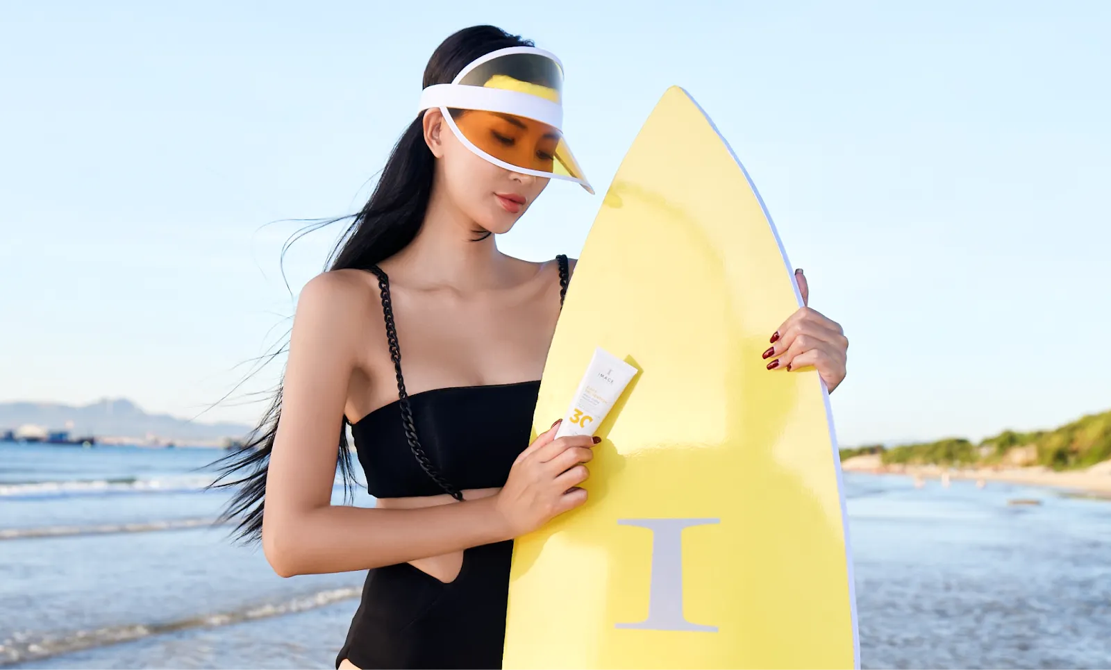 Hình ảnh người mẫu cùng Image Skincare Exosome Daily Prevention Sunscreen bên bãi biển.