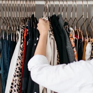 cô gái mặc áo trắng đứng sắp xếp tủ quần áo