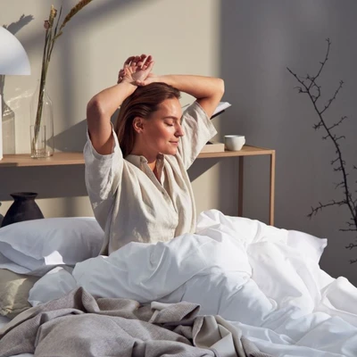 cô gái ngồi vươn vai trên giường