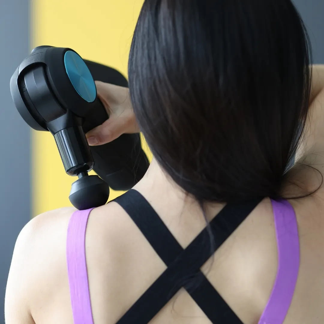 Hình ảnh cô gái đang sử dụng máy massage cho vùng vai.