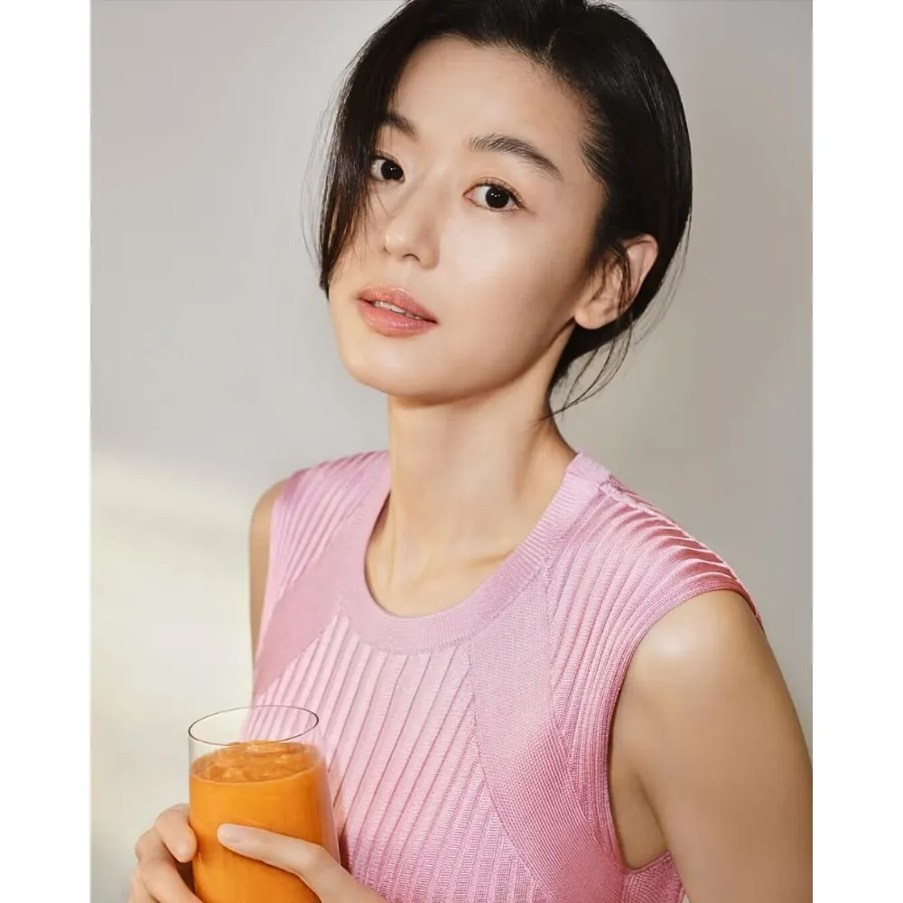 Cô gái mang áo hồng cầm ly nước ép