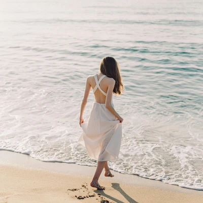 cô gái đang đi bộ trên bờ biển