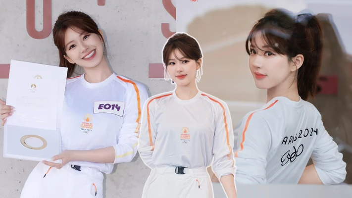 Triệu Lộ Tư mặc đồ thể thao màu trắng và mỉm cười tạo dáng để chụp hình tại Lễ rước đuốc Olympic Paris 2024