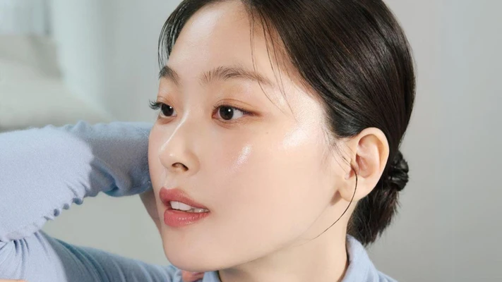 retinol sandwich - cô gái châu Á mặc áo xanh, búi tóc và trang điểm nhẹ nhàng để chụp hình chân dung