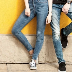 quần jeans nam và nữ đứng trước bức tường vàng
