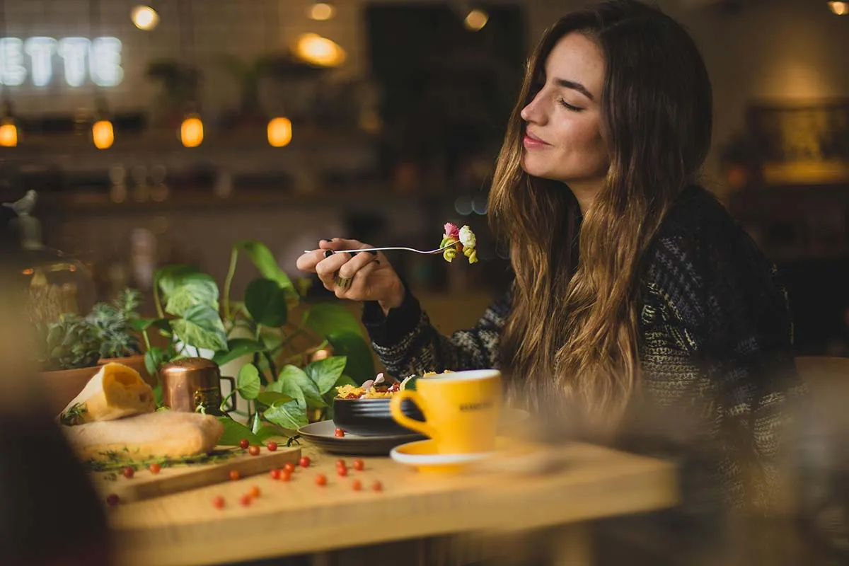 Cô gái ngồi ở bàn ăn có chế dộ dinh dưỡng cân bằng để nạp đầy năng lượng không cần đường hay cà phê