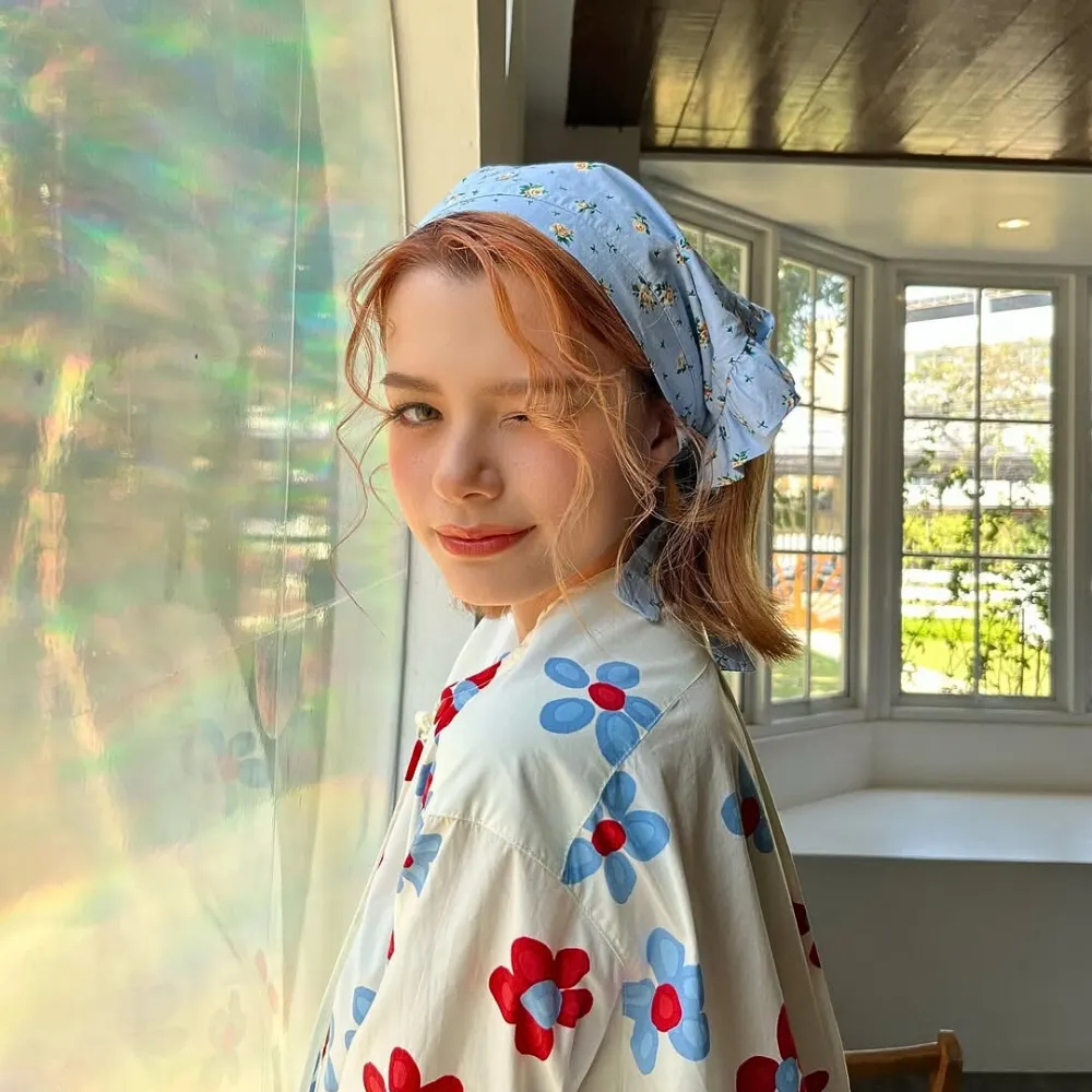 Rebecca mang áo sơ mi hoa và đội khăn màu xanh dương