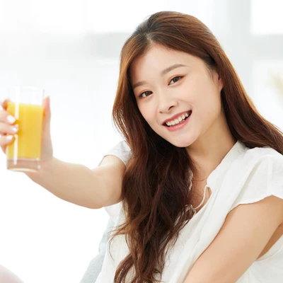 Cô gái cầm ly nước cam.