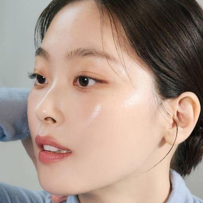retinol sandwich - cô gái châu Á mặc áo xanh, búi tóc và trang điểm nhẹ nhàng để chụp hình chân dung