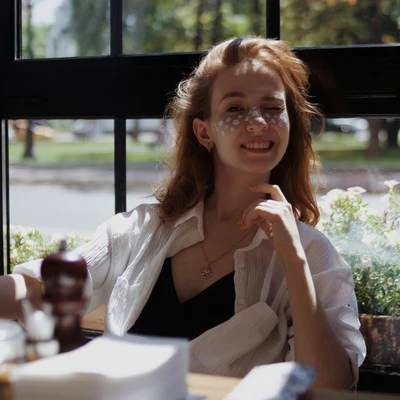 cô gái đang ngồi bên khung cửa sổ