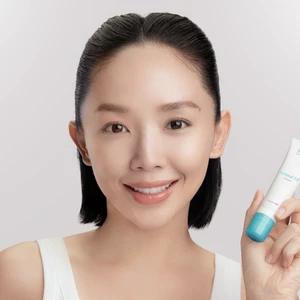 Obagi - ca sĩ Tóc Tiên mặc áo tank top màu trắng, buộc tóc nửa đầu, tay cầm tuýp kem dưỡng retinol của Obagi và nhìn chính diện vào camera để chụp ảnh chân dung